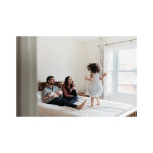 girl jumping on bed during Guildford family shoot